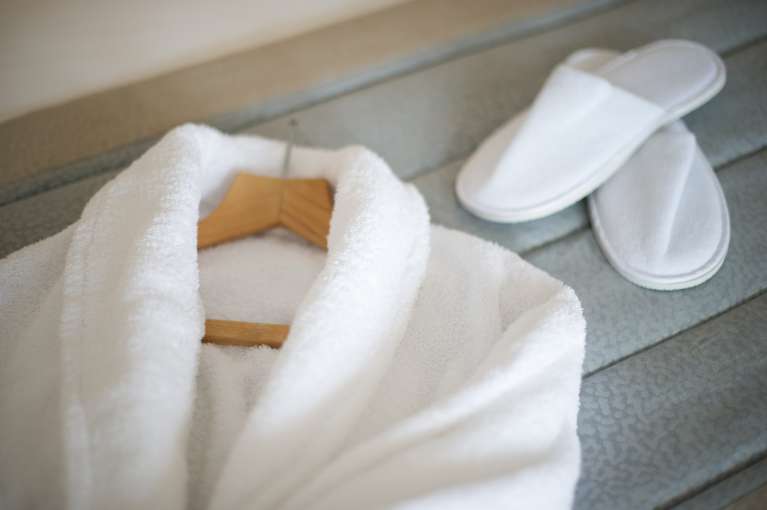 white robe and slippers on a bed