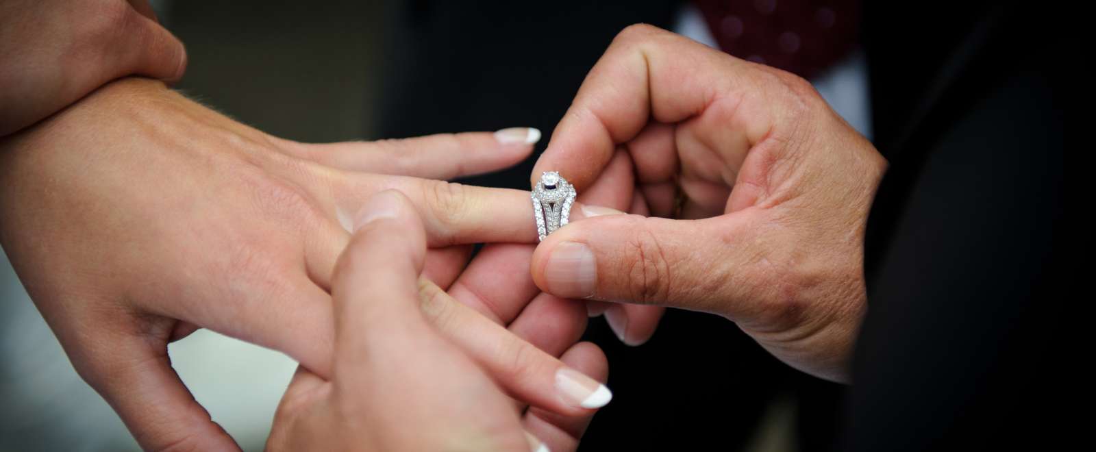 A groom putting a wedding ring on his bride's finger