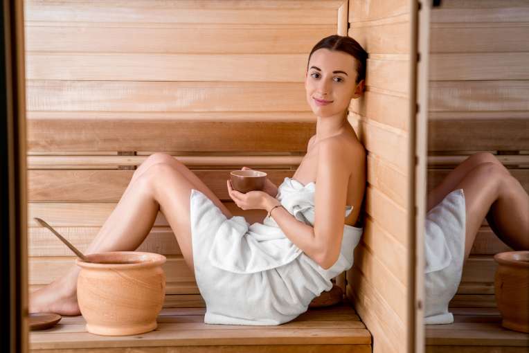Lady in sauna wearing white towel