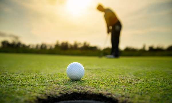 golf ball with golfers blurred in background