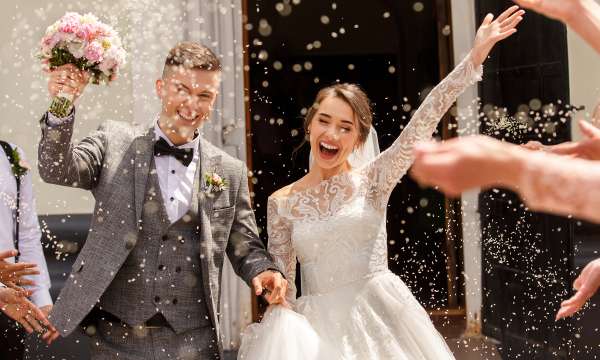 Newlyweds having confetti thrown over them