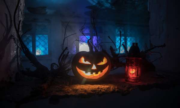 Scary Halloween pumpkin in the mystical house window at night