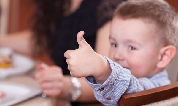 Child with their thumbs up