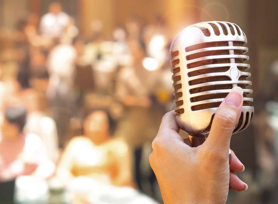 Womans hand on microphone at a wedding reception
