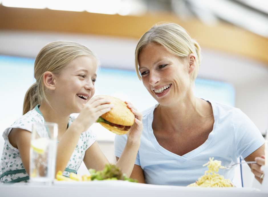 child eating burger with mother