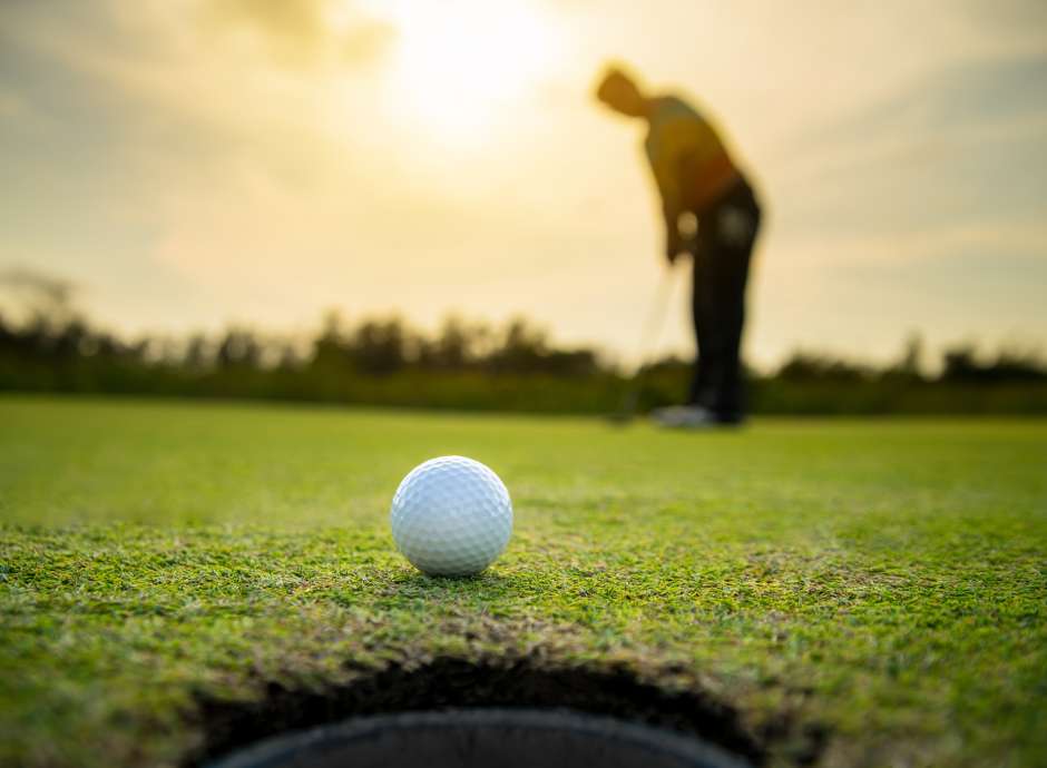 golf ball with golfers blurred in background