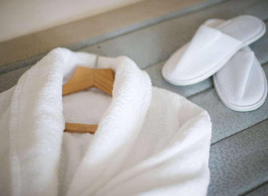 white robe and slippers on a bed