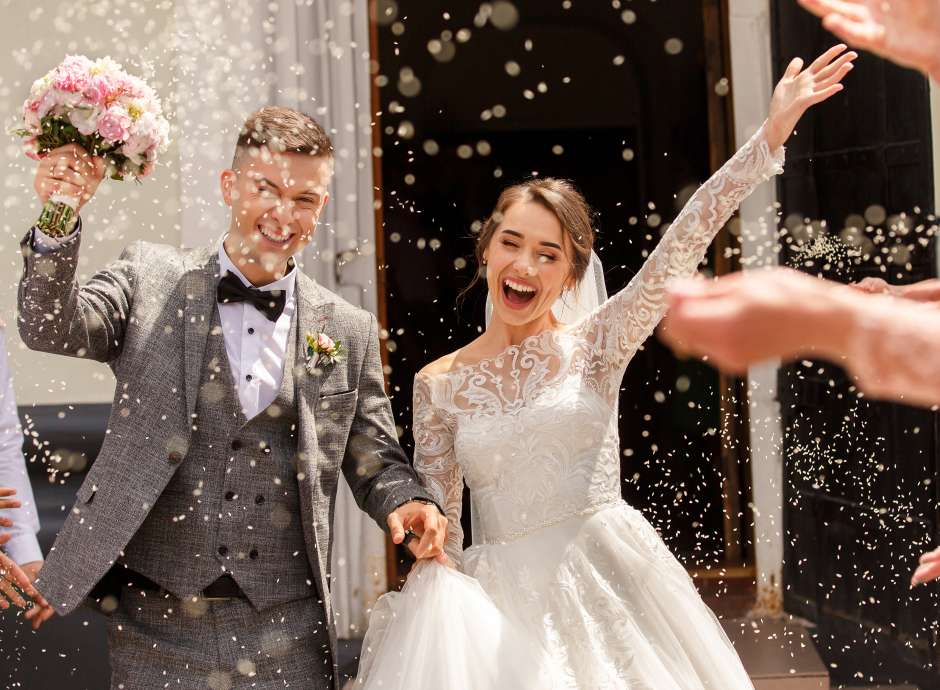 Newlyweds having confetti thrown over them