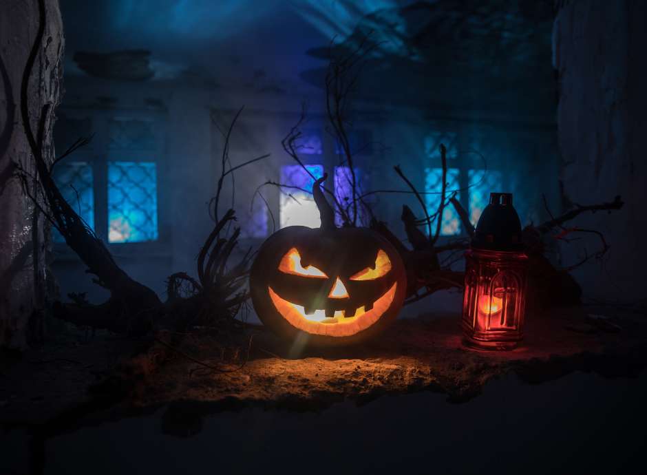 Scary Halloween pumpkin in the mystical house window at night