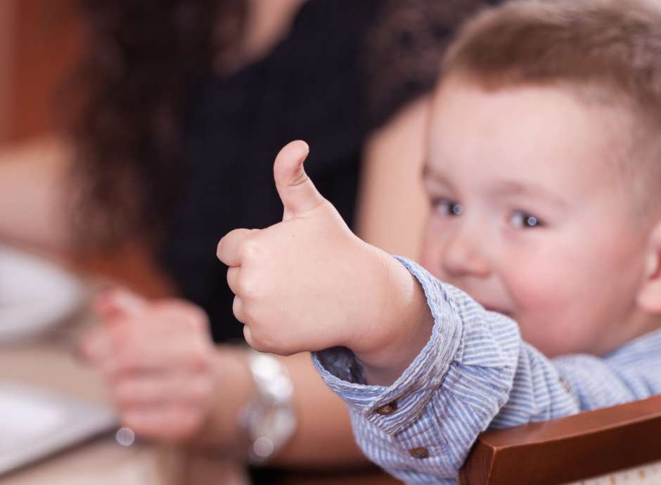 Child with their thumbs up